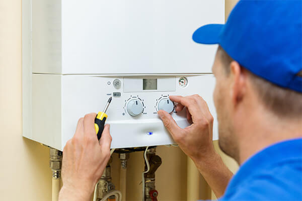 man with blue hat fixing furnace 