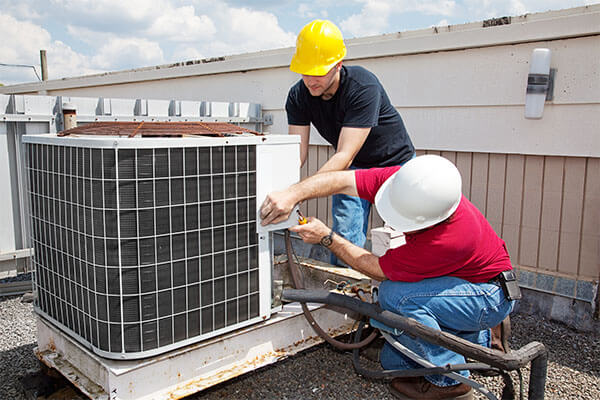 two techs working on unit outside 